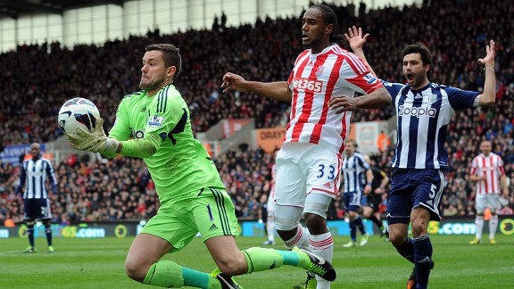 West Brom goalkeeper Ben Foster makes a save as Stoke striker Cameron Jerome closes in