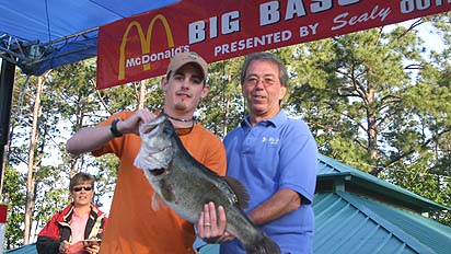 Cassidy Cole of Kilgore, Texas, leads after the second day of the McDonald;'s Big Bass Splash with this 11.08-pound lunker. He stands with tournament director Bob Sealy.